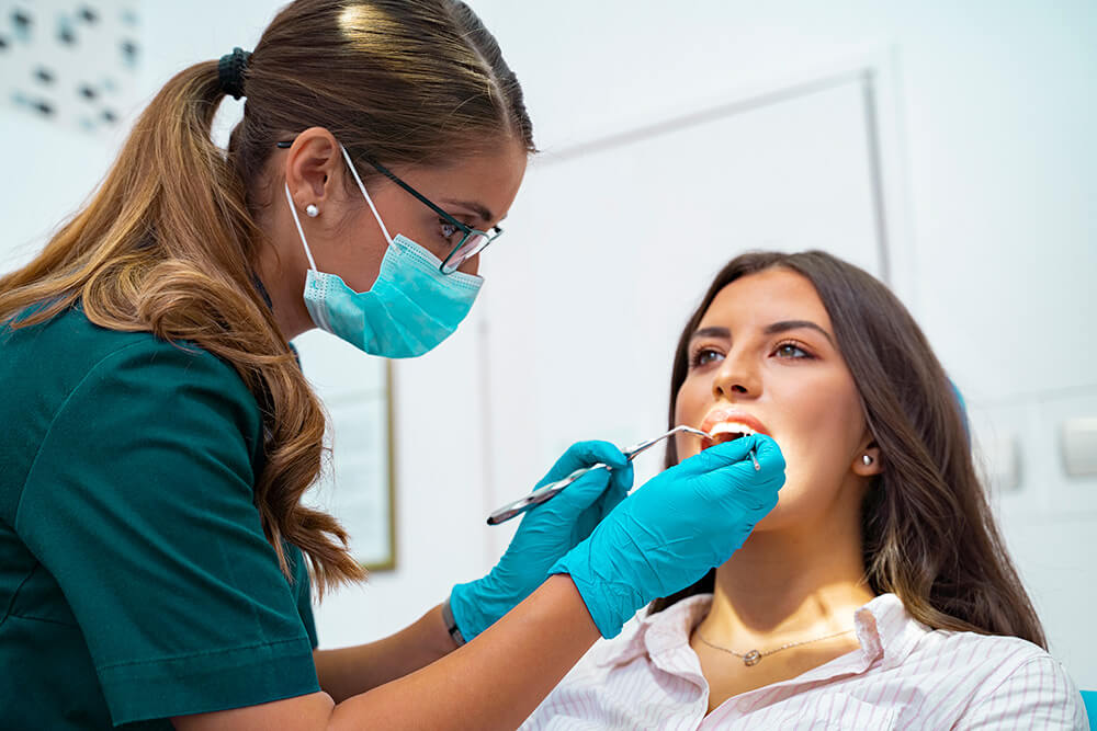 woman having her teeth cleaned by dental hygienist