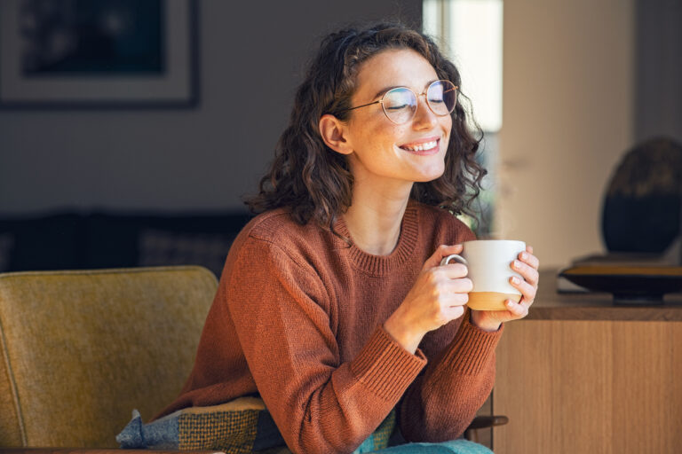 woman smiling with coffee mug in hand